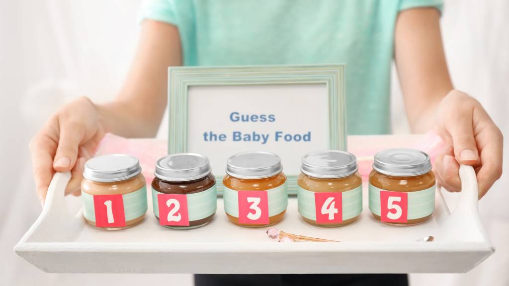 Baby food jars lined up for a guess the baby food game at a shower.