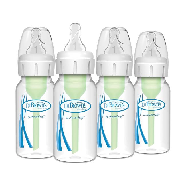 Dr. Brown’s Natural Flow Anti-Colic baby bottles arranged on a table with milk inside and bottle nipples attached.