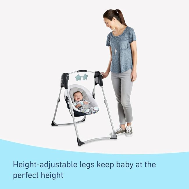 Parent placing baby in Graco Slim Spaces Reign swing