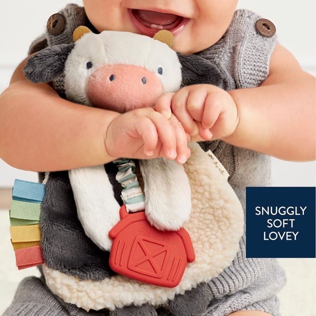 Soft and engaging Itzy Ritzy Itzy Lovey cow teether featuring ribbons, crinkle sounds, and plush fabrics for infants.